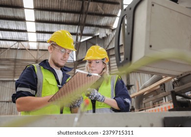 Two dedicated workers in safety attire focus intently on a checklist. Amidst the hum of machinery, they ensure every protocol is met, emphasizing the significance of thorough oversight - Powered by Shutterstock