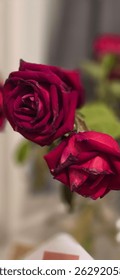 Two deep red roses in soft focus with a neutral background. A romantic and elegant floral composition, perfect for love and celebration themes.