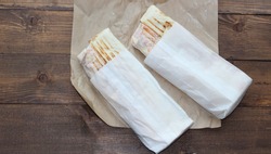 Two Delicious Shawarma On A Wooden Tabletop In Craft Paper. Nutritious And Harmful Food