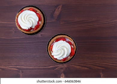 Two Delicious Strawberry Tarts With Chantilly Cream - Tartellete - On An Ipe Natural Wood Table - Top View