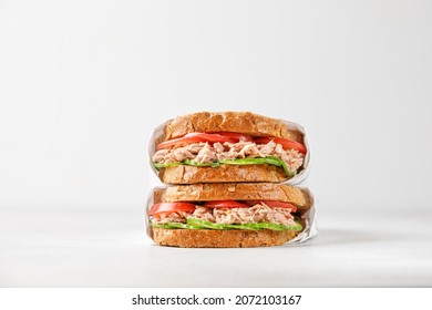 two delicious tuna sandwiches with tomato and cucumber in paper 