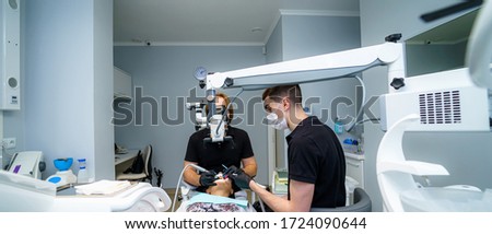 Two dentists examine the patient's teeth for the further treatment. Modern stomatology cabinet. Dentistry, medicine, medical equipment and stomatology concept.
