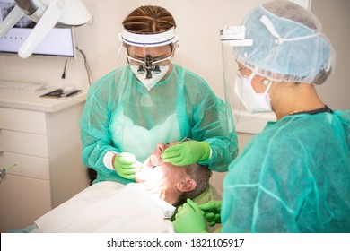 Two Dentists Examining A Male Patient