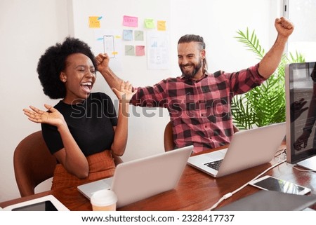 Two developers cheer with arms raised in office, successful launch of product