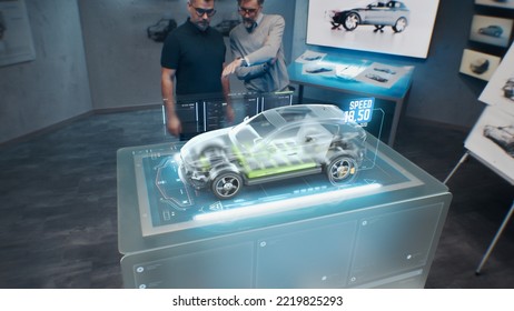 Two development engineers. Testing the speed performance of a cutting edge eco-friendly electric car with sustainable standards using an advanced, holographic augmented reality desk. - Shutterstock ID 2219825293