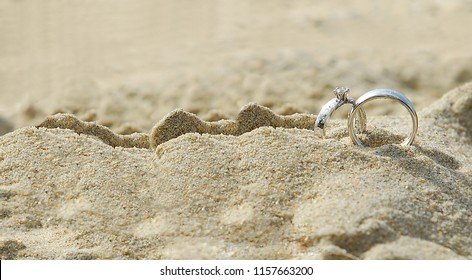 Two diamond rings on the sand. And they are wedding rings. backgrounds textures - Powered by Shutterstock
