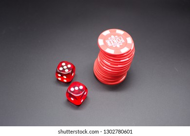 
Two dice beside stack of red poker chips