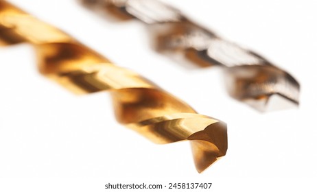 Two different colored drill bits are shown side by side. The gold one is on the left and the silver one is on the right
