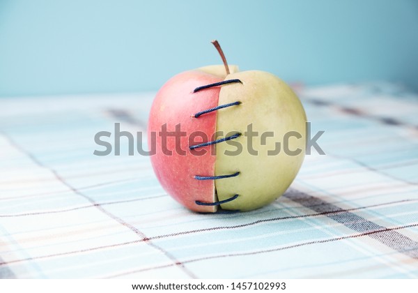 Two\
different halves of apple connected by\
thread