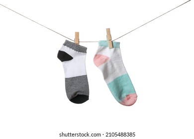 Two Different Socks Hanging On Rope Against White Background