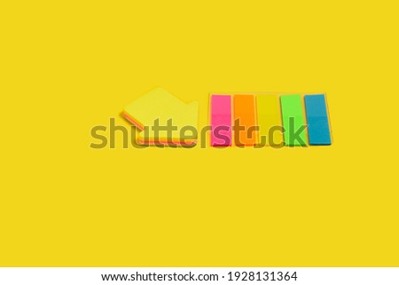 two different sticky note blocks lying isolated on yellow background. concept of office stationary. free space for advertising text