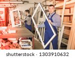 Two diligent friendly smiling workmen inspecting PVC manufacturing output in workshop