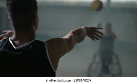 Two Disabled Athletes Playing With Basketball. Athlete With Disability Passes Ball To Team Member. People With Disability Training Before Game