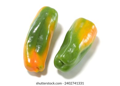 Two discolored substandard green peppers white background