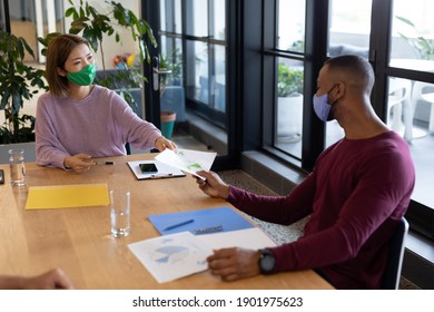 Two Diverse Business People Working In Creative Office. Two People In A Meeting Discussing Work. Social Distancing Protection Hygiene In Workplace During Covid 19 Pandemic.