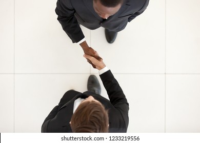 Two Diverse Businessmen Shaking Hands In Office, Black And White Partners Greeting With Handshake As Respect Concept, Collaboration Deal, Support, Business Acquaintance, First Impression, Top View