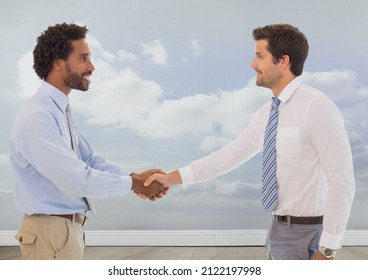 Two diverse businessmen shaking hands against clouds in the sky. global business and partnership concept