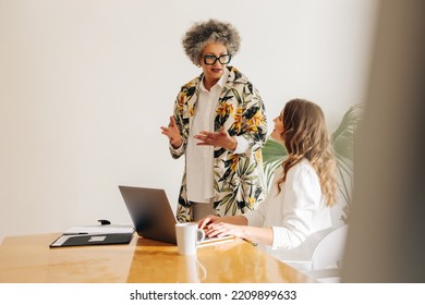 Two Diverse Businesswomen Having A Discussion In A Modern Meeting Room. Creative Businesswomen Collaborating On A New Task In A Woman-owned Startup.