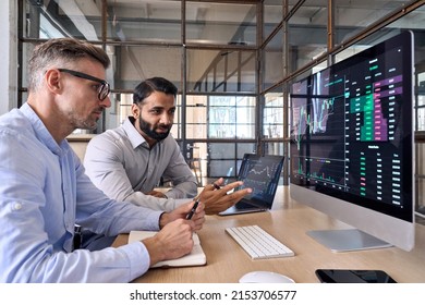 Two diverse crypto traders brokers stock exchange market investors discussing trading charts research reports growth using pc computer looking at screen analyzing invest strategy, financial risks. - Shutterstock ID 2153706577