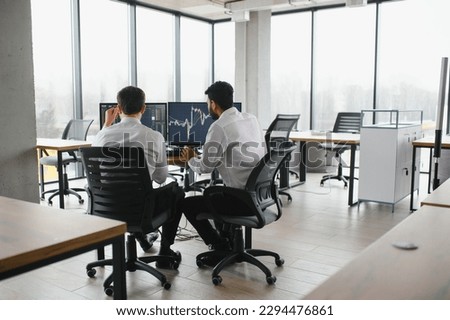 Two diverse crypto traders brokers stock exchange market investors discussing trading charts research reports growth using pc computer looking at screen analyzing invest strategy, financial risks