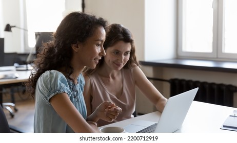 Two Diverse Employees Working On Project Tasks Together, Sharing Laptop, Watching Online Presentation, Making Video Call. Company Teacher Training Intern. Business Communication Concept