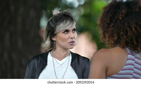 Two Diverse Friends Talking Outside At Park. People Conversation