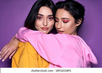 Two Diverse Girls Lesbian Couple Hugging Looking At Camera, Close Up Portrait. Stylish Cool Generation Z Women Dating In Love Enjoy Romantic Relationships Isolated On Purple Background. Lgbtq Concept