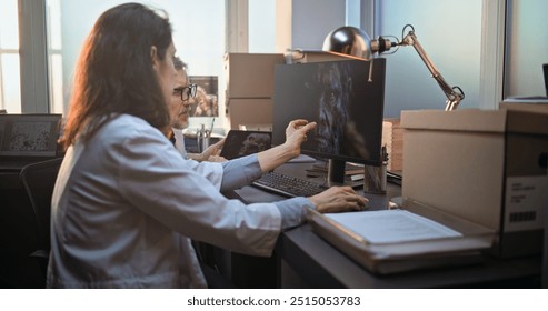 Two diverse scientists discuss 3D visualization of ancient human head anatomy displayed on PC and tablet computer screen, conduct historical research. Archaeologists work in archaeological laboratory. - Powered by Shutterstock - Get 15% off with code: PIKWIZARD15
