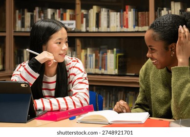 Two diverse students studying and collaborating on a project in a school library