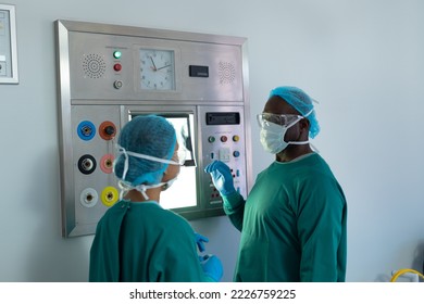 Two diverse surgeons discussing x-ray on lightbox in operating theatre. Hospital, medical and healthcare services. - Powered by Shutterstock - Get 15% off with code: PIKWIZARD15