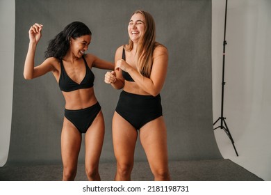 Two diverse women in their black underwear having fun in the studio