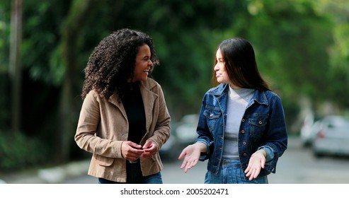 Two Diverse Young Women Chatting In Conversation Outside