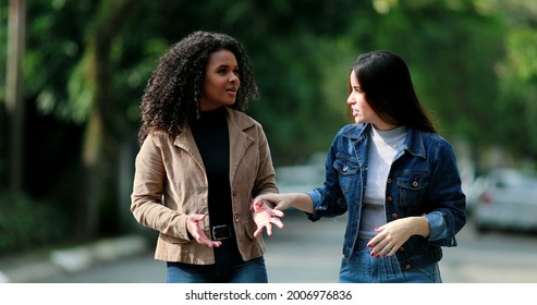 Two Diverse Young Women Chatting In Conversation Outside