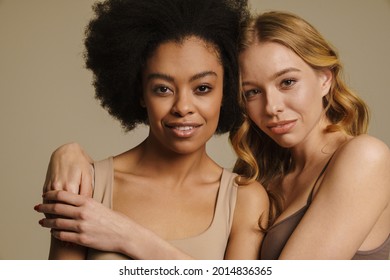 Two Diverse Young Women In Underwear Standing Over Beige Background Close Up