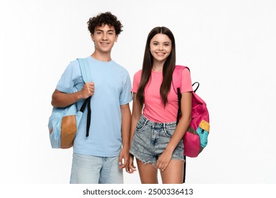 Two diversity high school pupils students teenagers classmates boy and girl in casual clothes with bag standing posing looking at camera isolated on white background. Education back to school concept