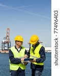 Two dockers discussing procedures and plans at the waters edge