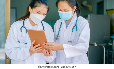 Two Doctors Consulted Medical Information, Using IPad Online Technology In The Patient  Room ,health Concept, Outbreak Of Disease, Selective Focus