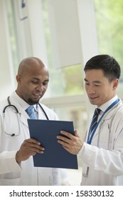 Two Doctors Consulting Over Medical Record In The Hospital