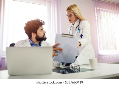 Two doctors discussing about patient report in ward at hospital. - Shutterstock ID 1037660419