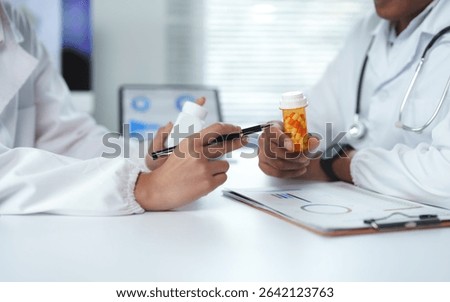 Two doctors are discussing about pills and treatments using graphs in a hospital