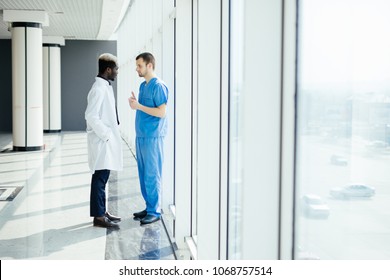 Zwei Ärzte, die die Diagnose beim Gehen im Krankenhaus erörtern