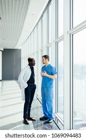 Two doctors discussing diagnosis while walking in hospital