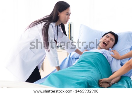 Two doctors holding a psycho patient on bed in hospital