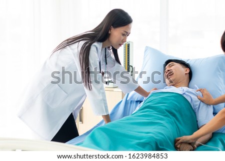 Two doctors holding a psycho patient on bed in hospital