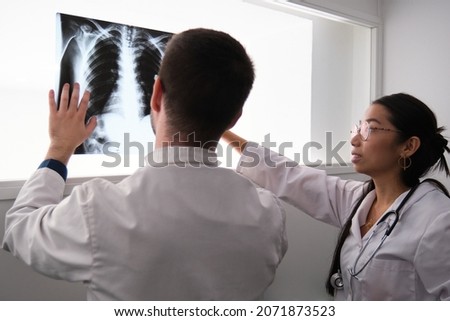 Two doctors interpreting a ribs x-ray image.