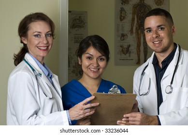 Two Doctors And Nurse Discussing Lab Results Stop And Smile At The Camera.