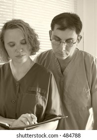 Two Doctors; Nurses; Medical Students Review Patient Chart