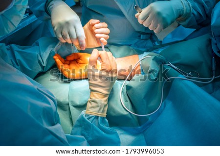 two doctors operate on a wrist fracture in an operating theatre