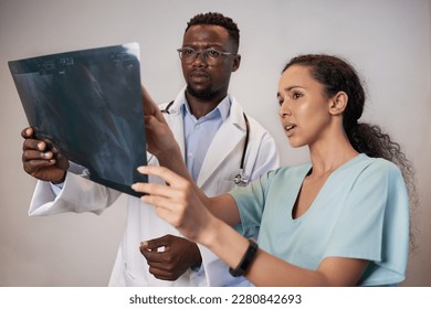 Two doctors review patient x-ray and discuss medical surgery treatment - Powered by Shutterstock