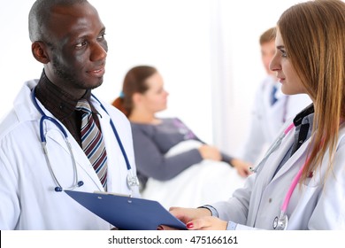Two doctors share and discuss important document on clipboard pad. Human interaction, professional dispute, therapeutist prescribe remedy, physical, illness prevention, 911, healthy lifestyle concept
